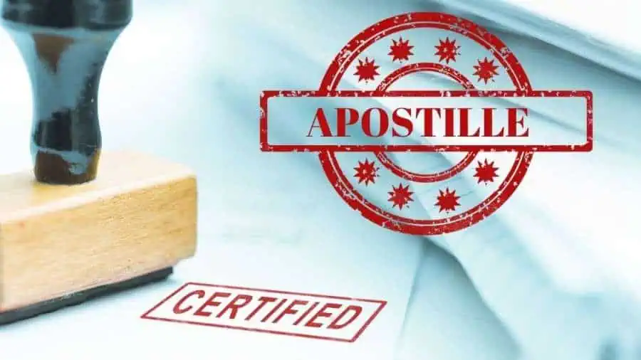 A red apostille stamp being applied to a document